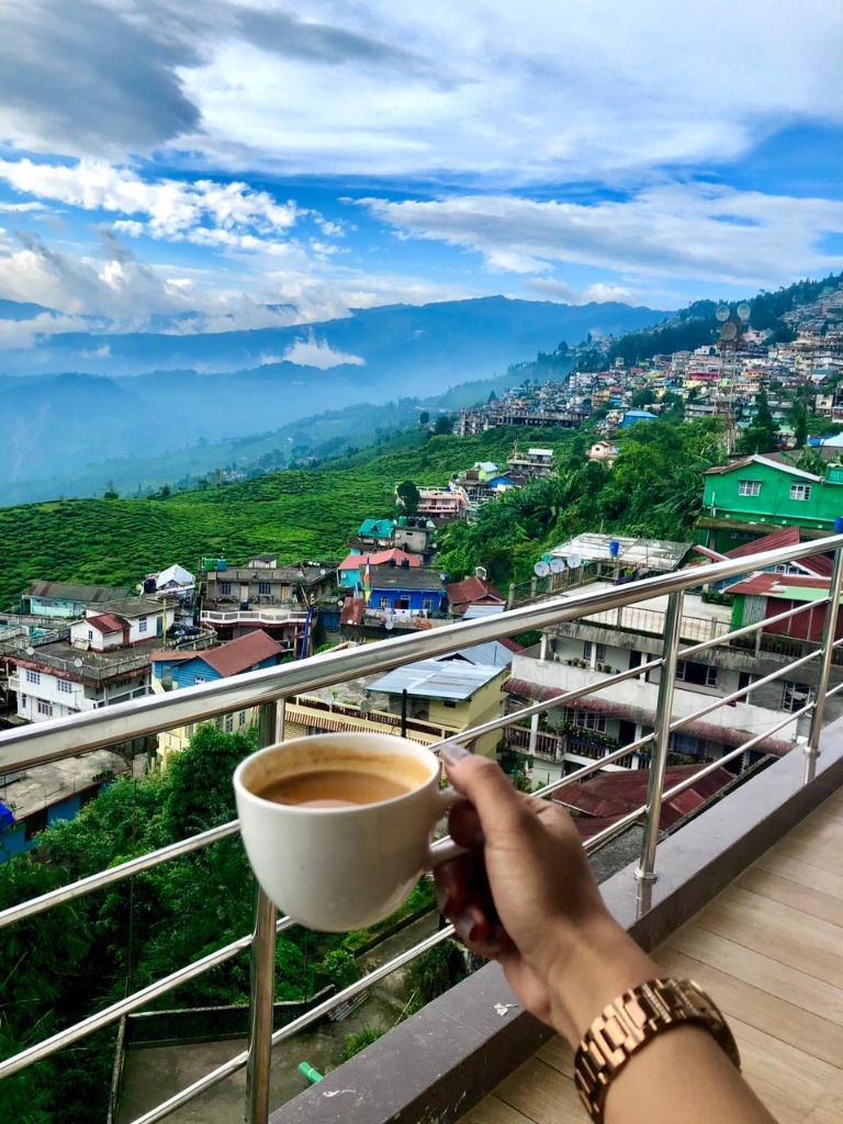 Enjoying a warm cup of Darjeeling tea on the balcony overlooking tea gardens