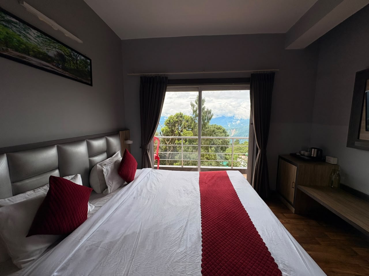 Deluxe Room expansive mountain and tea-estate view through wide glass doors